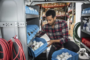 Worker pulling bins off of customized van shelving